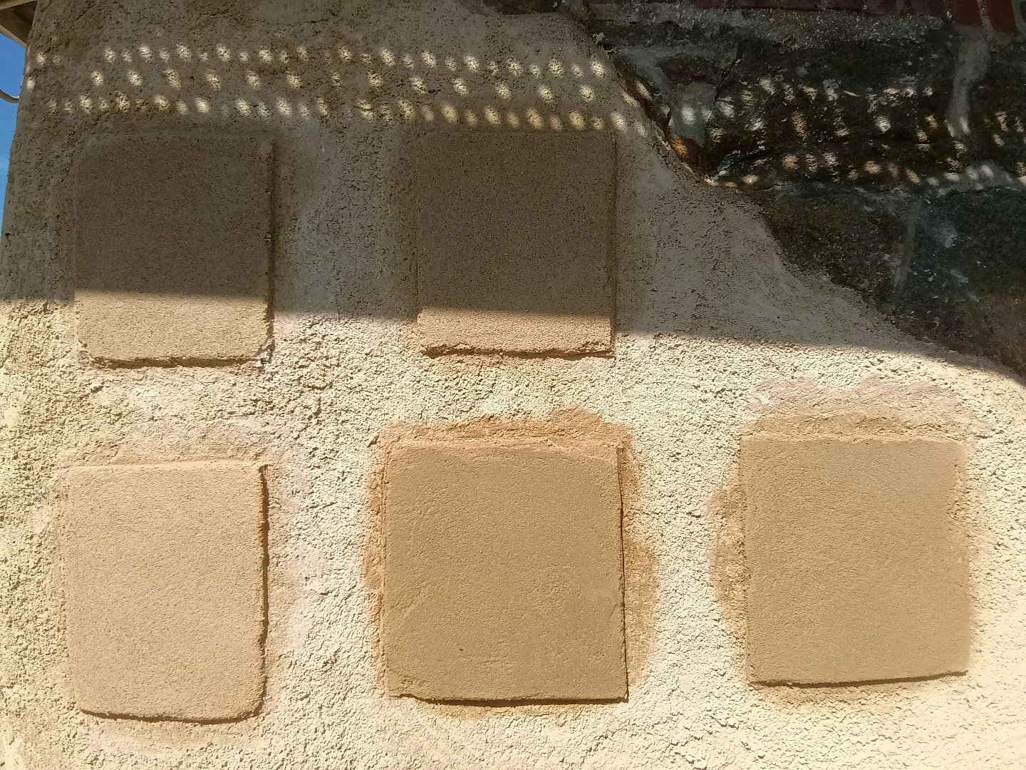 Essais de teintes d'enduit à la chaux posés sur le mur